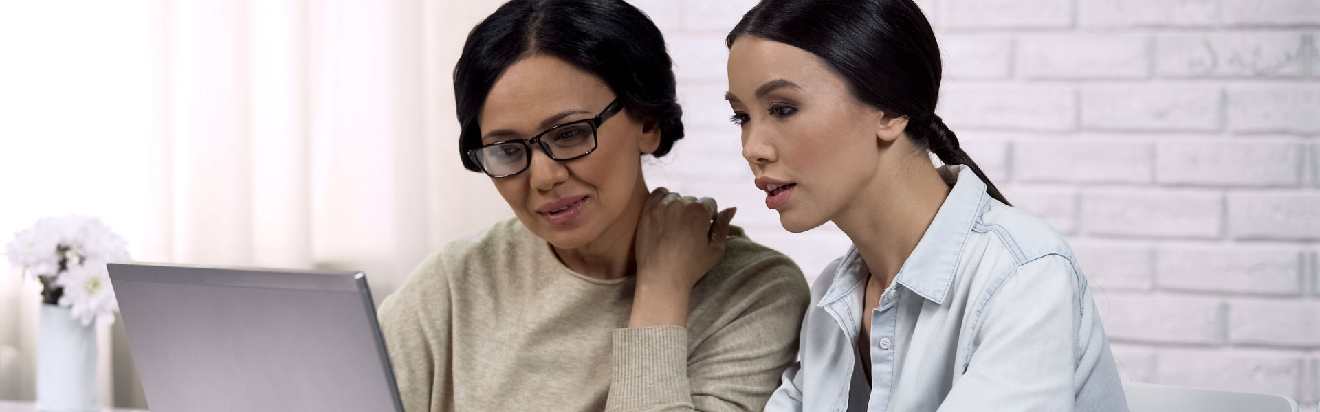 two women using a laptop