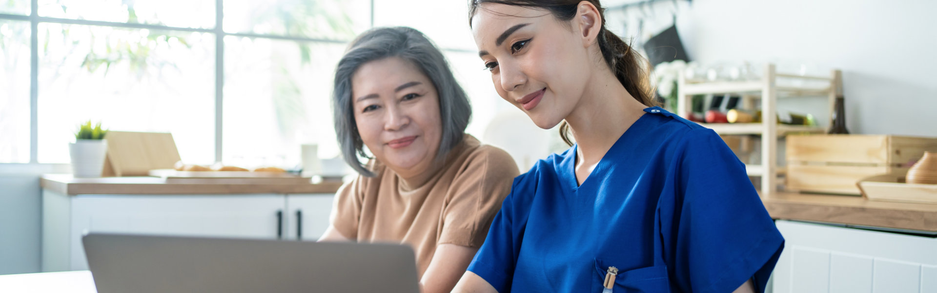 two women using a laptop