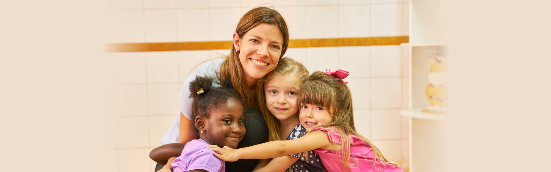 Children and caretaker happily smiles and hugs each other